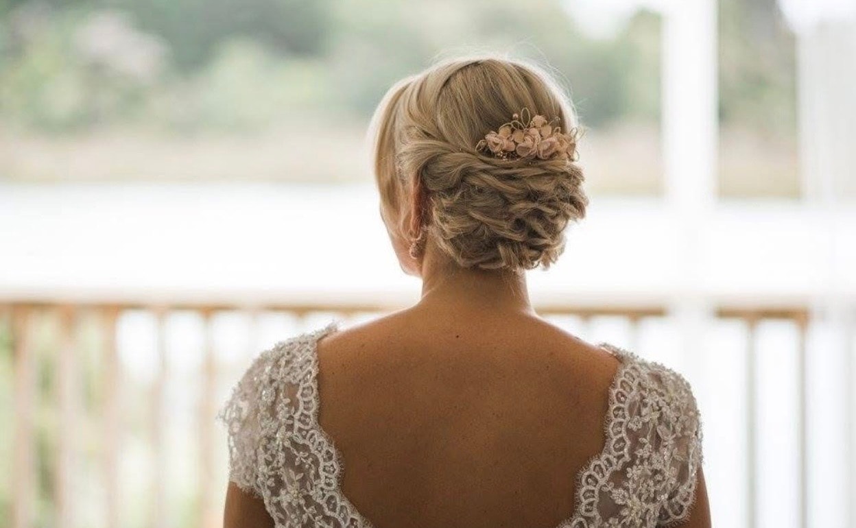Bride wearing an elegant updo with a floral hairpiece